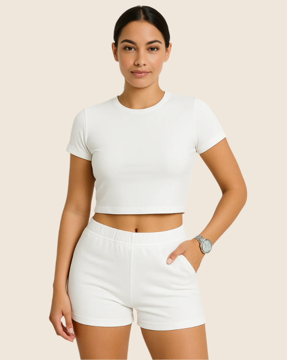 Woman wearing a white crop top and shorts on a beige background